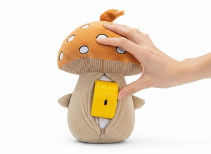 Eine Hand setzt den Lenabo Smart Speaker in die geöffnete Innentasche eines Lenabo Plüschcharakters (Lenabies) ein. Der Reißverschluss auf der Rückseite ist geöffnet, und der kompakte Lautsprecher wird bequem eingeschoben. Dies ermöglicht die smarte Steuerung via Lenabo App zur altersgerechten Wiedergabe von Audioinhalten.