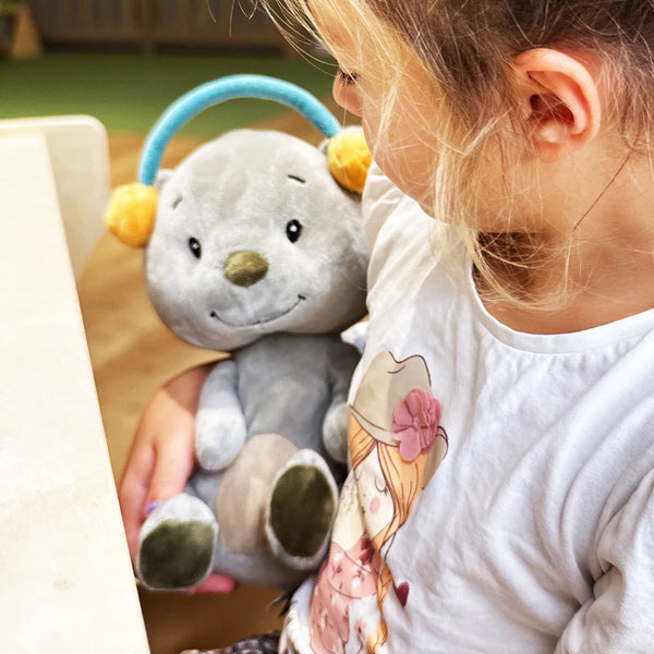 Lenabie Aaron (Bär) begleitet ein Kind als kuscheliger Audiobegleiter – perfekt für Geschichten, Musik und entspannte Momente.