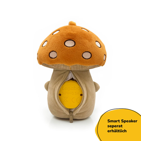 Rückansicht von Lenabie Felix (Pilz) mit geöffnetem Reißverschlussfach und eingesetztem Lenabo Smart Speaker – das Soundmodul ist herausnehmbar, sodass das Kuscheltier waschbar bleibt („Smart Speaker separat erhältlich“).